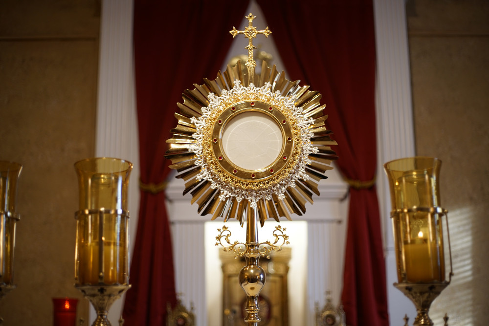 A monstrance with a candle on either side.